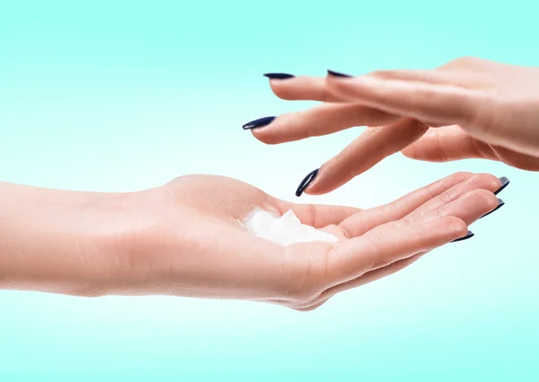 Hermosas manos femeninas con crema — Foto de Stock