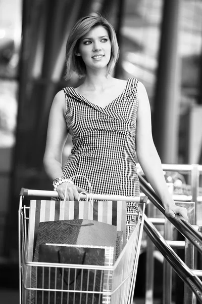 Loira bonita com carrinho de compras — Fotografia de Stock