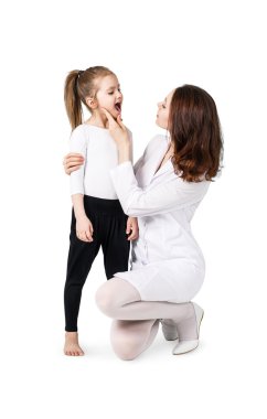 Küçük kızın boğazını inceleyerek doktor
