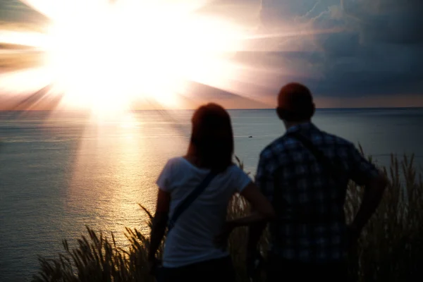 Jovem casal desfrutando do pôr do sol . — Fotografia de Stock