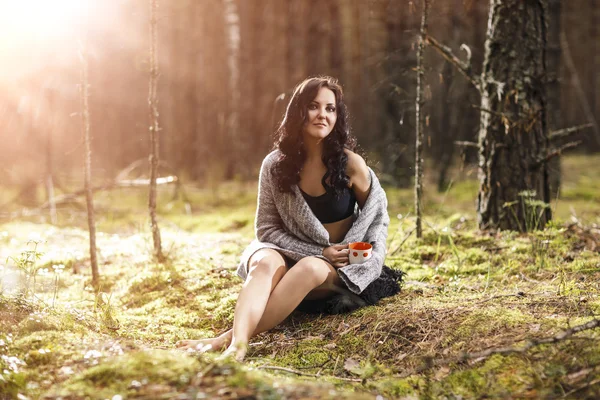 Piękna kobieta siedzi w lesie — Zdjęcie stockowe