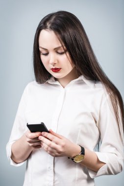 Cep telefonu kullanan genç bir kadın.