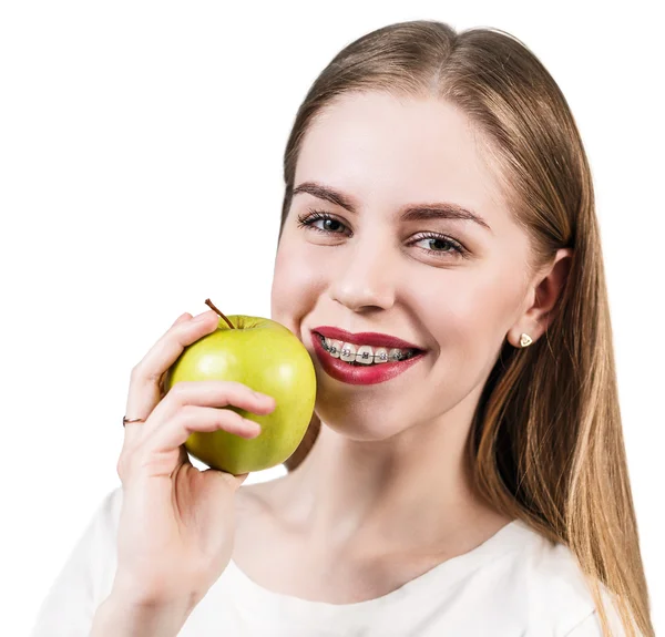 Mujer joven con paréntesis en los dientes comiendo manzana — Foto de Stock