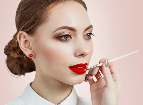 Jonge vrouw die lippenstift aanbrengt met een applicator — Stockfoto