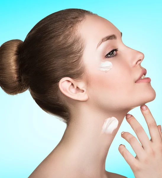 Hermoso modelo aplicando crema en la cara — Foto de Stock