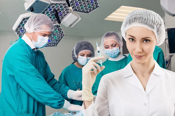 Anesthetist with syringe and surgery teem — Stock Photo, Image