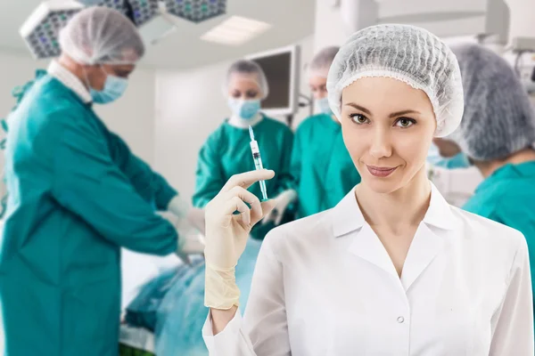 Anesthetist with syringe and surgery teem — Stock Photo, Image