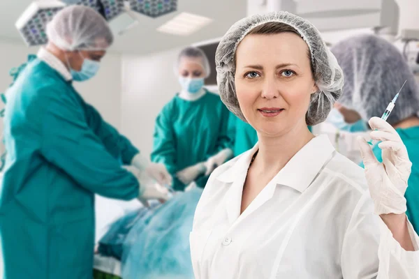 Anesthetist with syringe and surgery teem — Stock Photo, Image