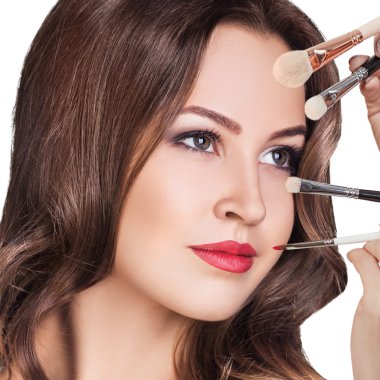 Makyaj fırçalı genç bir kadın.