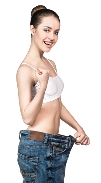 Slim girl in big jeans showing result — Stock Photo, Image