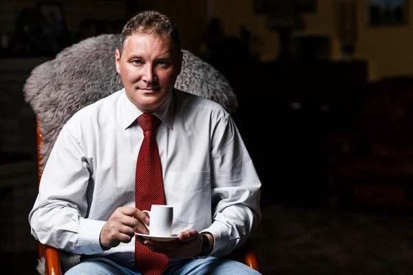 Серьезный бизнесмен средних лет с чашкой кофе — стоковое фото