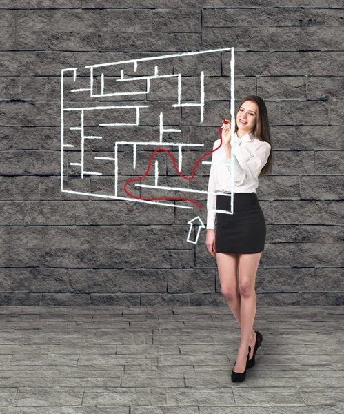 Schöne Geschäftsfrau zeigt etwas im Labyrinth — Stockfoto
