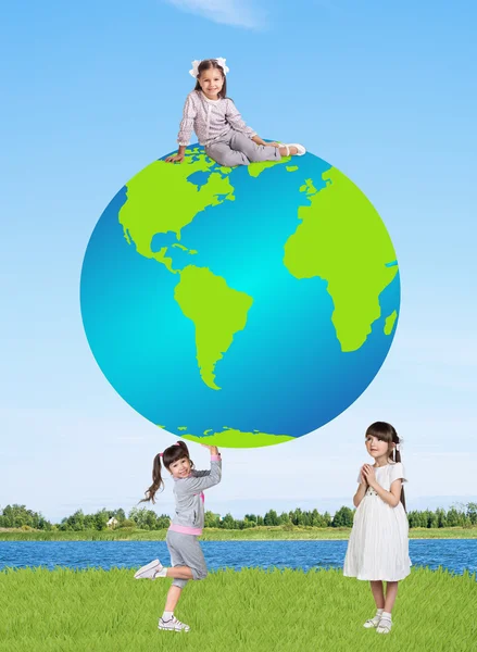 Kleine lächelnde Mädchen mit einer Weltkugel — Stockfoto