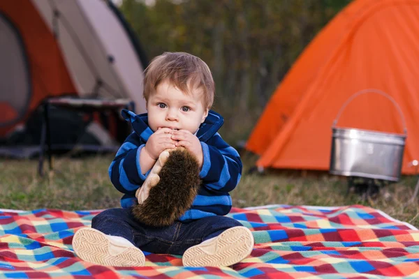 Liten pojke leker med en nalle i gräset — Stockfoto