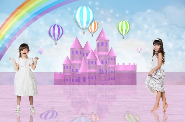 Two little girls in front of a pink fairy castle — Stock Photo, Image