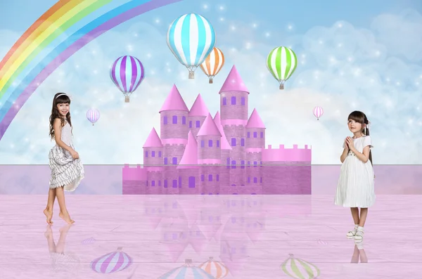 Two little girls in front of a pink fairy castle — Stock Photo, Image