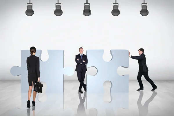 Team of business people try to join puzzle — Stock Photo, Image