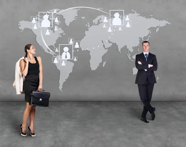 Businessmen standing in front of an earth map — Stock Photo, Image