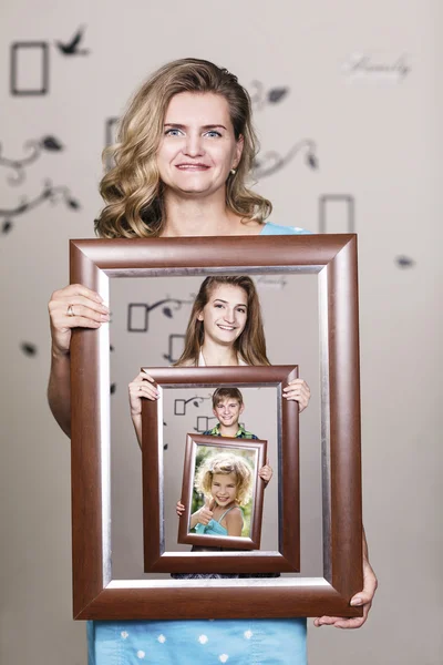 Happy mother holding portrait with her family
