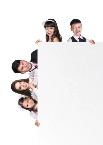 Bela família divertida atrás de um branco em branco — Fotografia de Stock