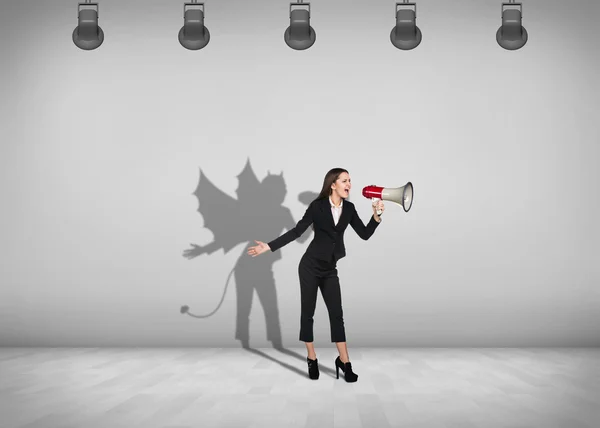Бізнес-леді стоїть з тіні на стіні — стокове фото