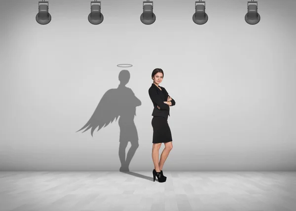 Businesswoman stands with shadow on the wall — Stock Photo, Image