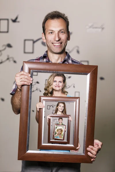 Happy father holding portrait with his family — Stock Photo, Image