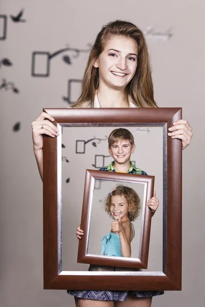 Irmã adulta segurando retrato com sua família — Fotografia de Stock