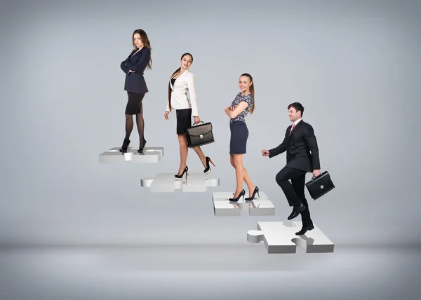 Business people stand on puzzle stairs — Stock Photo, Image