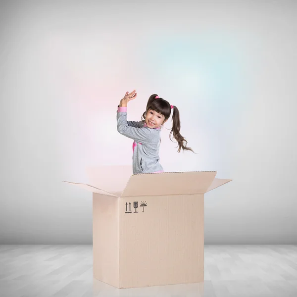 Beautiful little girl inside a cardboard box — Stock Photo, Image