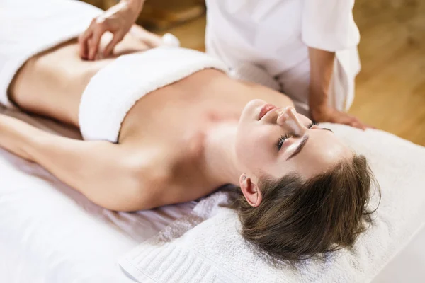 Donna gode di massaggio di pancia al centro benessere — Foto Stock