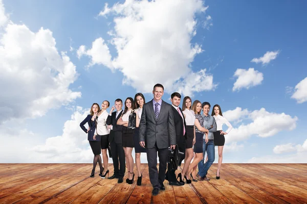 Groep van zakelijke mensen staan onder wolken hemel. — Stockfoto