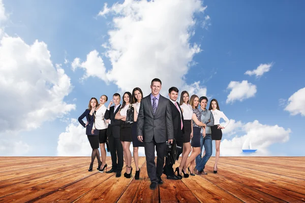 Group of business people stand under clouds sky. — Stock Photo, Image