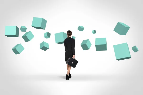 Business woman looking at turquoise cubes — Stock Photo, Image