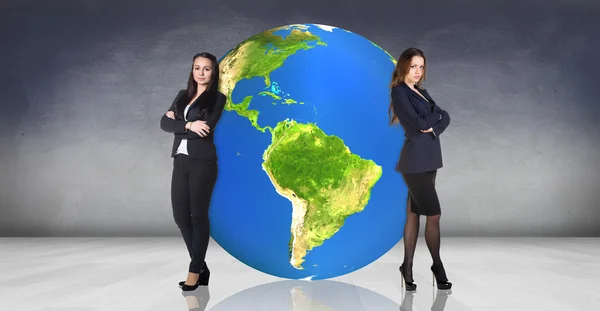 Geschäftsfrauen lehnen sich auf der großen Erde zurück — Stockfoto