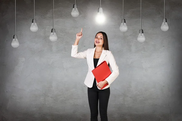 Business woman in room with hanging bulbs — Stock Photo, Image