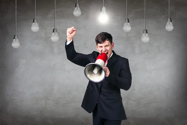 Businessman in the room with hanging bulbs — Stock Photo, Image