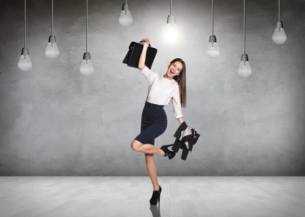 Business woman in room with hanging bulbs — Stock Photo, Image