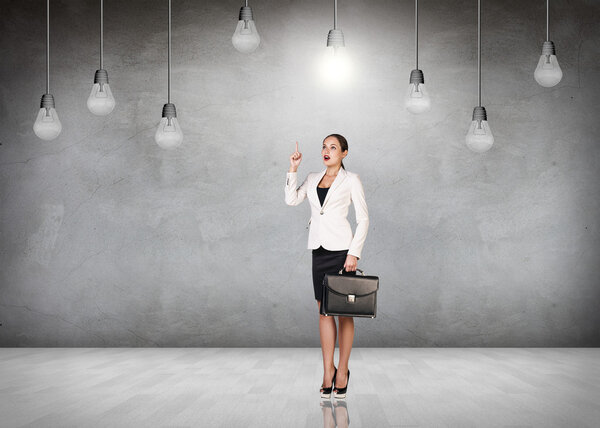 Business woman in room with hanging bulbs
