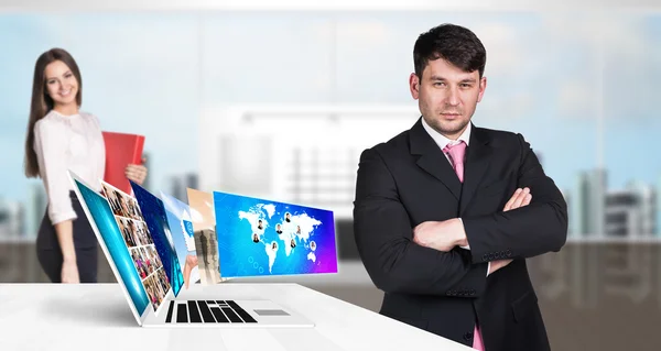 Επιχειρηματίας που στέκεται κοντά σε φορητό υπολογιστή με πολλές οθόνες. — Φωτογραφία Αρχείου