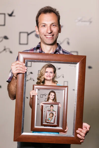Šťastný otec drží portrét s rodinou — Stock fotografie