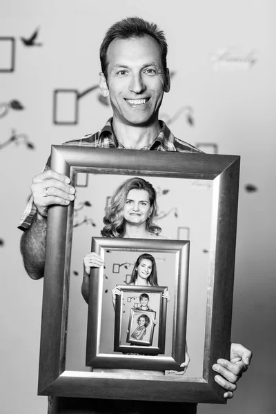 Pai feliz segurando retrato com sua família — Fotografia de Stock