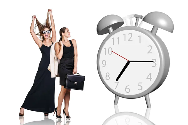 Le donne d'affari stanno vicino a grande sveglia grigia — Foto Stock