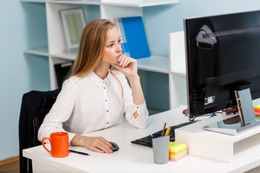 Masa başında bilgisayarla oturan kadın