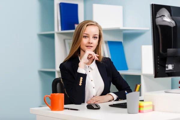 Kvinna sitter vid skrivbordet med dator — Stockfoto