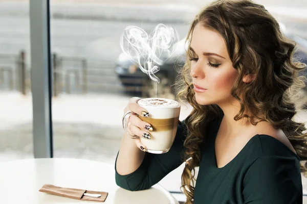 Donna seduta al bar con una tazza di latte macchiato — Foto Stock