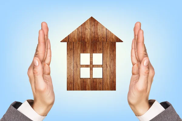 Wooden house in human hands — Stock Photo, Image