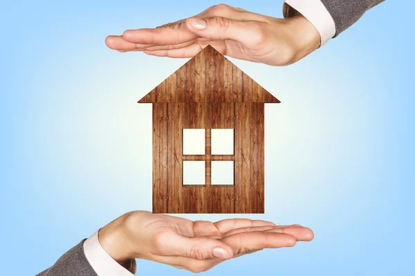 Wooden house in human hands — Stock Photo, Image