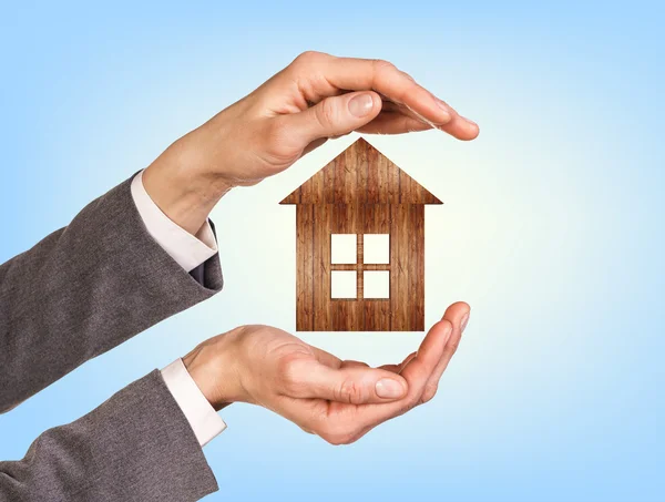 Wooden house in human hands — Stock Photo, Image