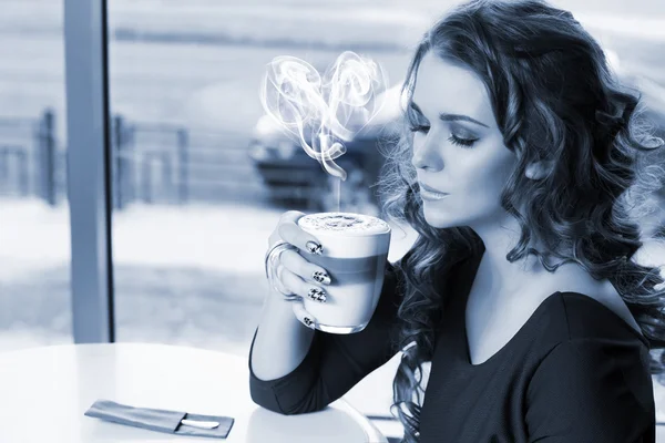 Femme assise dans le café avec une tasse de latte — Photo